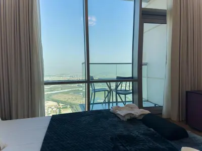 a bedroom with a bed and a table with chairs at Modern and Spacious 2BR in Business Bay in Dubai