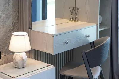 a dresser in a room with a lamp and a chair at DVR 2BR in 15 Northside Business bay in Dubai