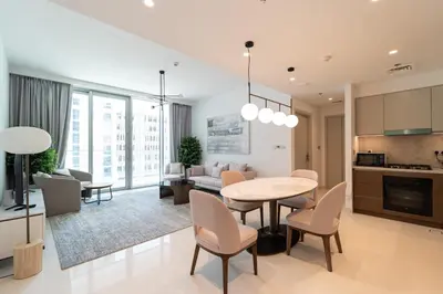 a kitchen and living room with a table and chairs at Golden Coast Stay in Dubai