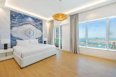 a bedroom with a white bed and a large window at Daniels 3BR with Palm View at Marina Pinnacle in Dubai