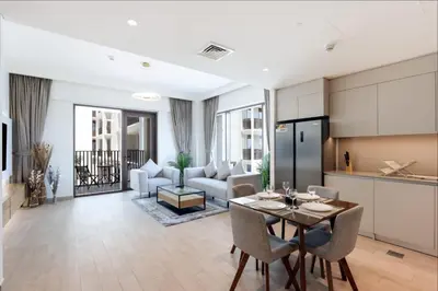 a kitchen and living room with a table and chairs at Livbnb-Elegant 2BR, Creek Beach, Pool & Gym in Dubai
