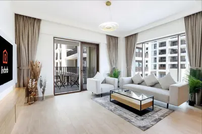 a living room with a couch and a coffee table at Livbnb-Elegant 2BR, Creek Beach, Pool & Gym in Dubai