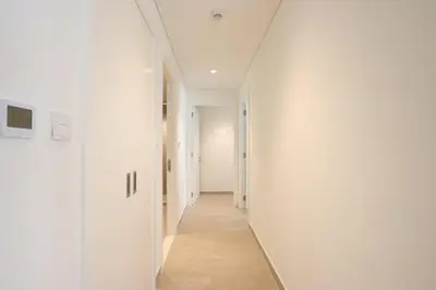 an empty hallway with white walls and wood floors at Livbnb-Elegant 2BR, Creek Beach, Pool & Gym in Dubai