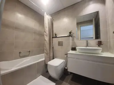 a bathroom with a sink and a toilet and a tub at DVR Studio apartment available in Damac Hills in Dubai