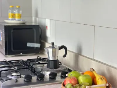 a bowl of fruit sitting on a stove with a blender at Sunsets and Skylines 1BR in Panoramic Tower in Dubai
