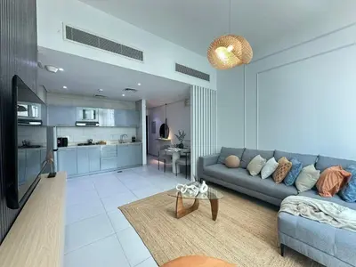a living room with a couch and a table at Sunsets and Skylines 1BR in Panoramic Tower in Dubai
