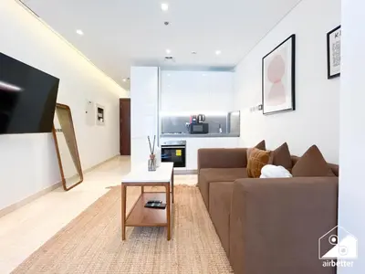 a living room with a couch and a table at Streling Studio with Balcony & City Views in Dubai