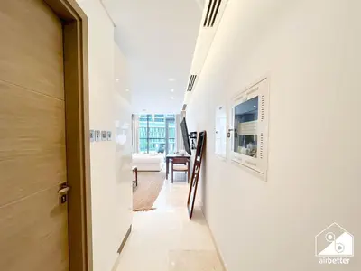a hallway with a white wall and a door at Streling Studio with Balcony & City Views in Dubai