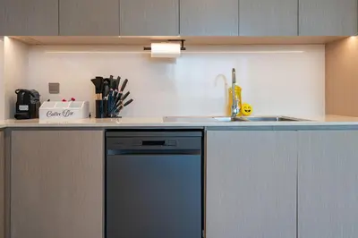 a kitchen with a dishwasher and a sink at Luxury Stay with Burj views in Dubai