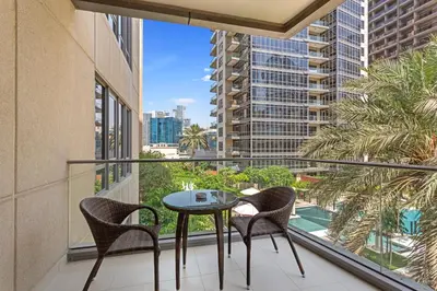 a balcony with a table and chairs and a view of a city at Exceptional 1-bedroom with pool view in Downtown in Dubai