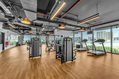a gym with treadmills and elliptical machines at Waves - Rustic Chic 1 BR Retreat in Vibrant JVC in Dubai