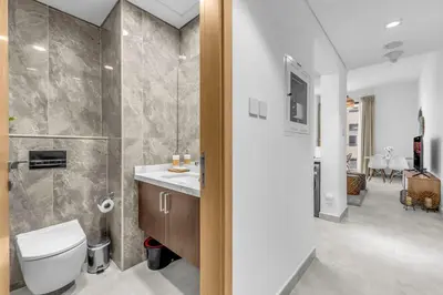 a bathroom with a toilet and a sink at Waves - Rustic Chic 1 BR Retreat in Vibrant JVC in Dubai