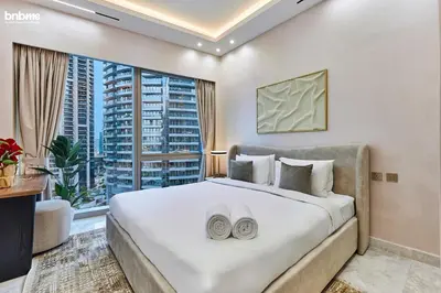 a bedroom with a large bed and a large window at bnbme - Luxury Downtown Dubai Apt Burj Khalifa Fountain Views Pool Gym Parking in Dubai