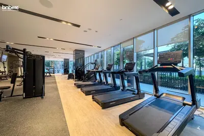 a gym with a row of treadmills and ellipticals at bnbme - Luxury Downtown Dubai Apt Burj Khalifa Fountain Views Pool Gym Parking in Dubai