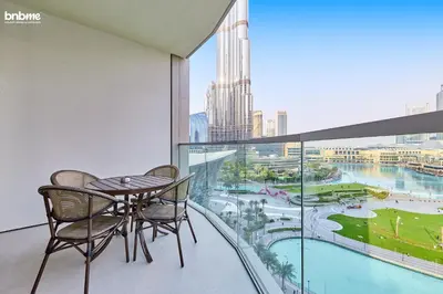 a balcony with a table and chairs and a view of the city at bnbme - Luxury Downtown Dubai Apt Burj Khalifa Fountain Views Pool Gym Parking in Dubai