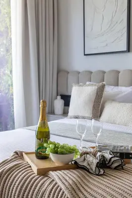 a tray with a bottle of wine and grapes on a bed at Frank Porter - Al Jawhara Tower in Dubai