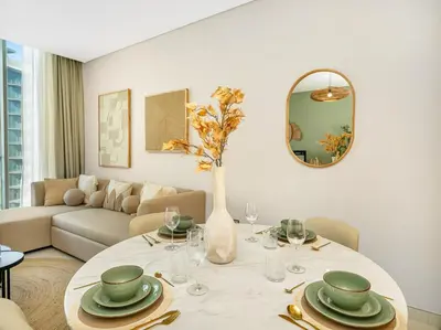 a living room with a table with a vase with flowers at Stunning Central 2BR Lagoon View & Private Beach in Dubai