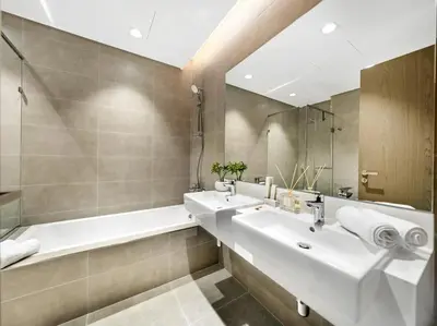 a bathroom with two sinks and a tub and a mirror at Stunning Central 2BR Lagoon View & Private Beach in Dubai