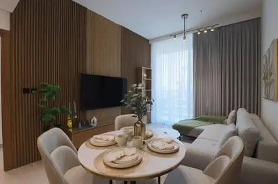 a living room with a table and a couch at Gracious 1BR in Binghatti Amber in Dubai