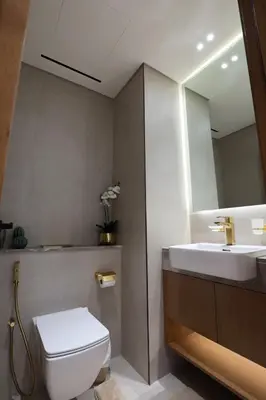 a bathroom with a sink and a toilet and a mirror at Gracious 1BR in Binghatti Amber in Dubai