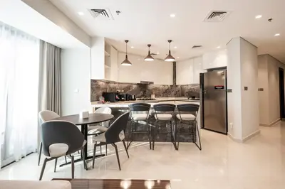 a kitchen with a table and chairs and a refrigerator at Luxurious Apt 2BR Stunning Full Burj Khalifa view in Dubai