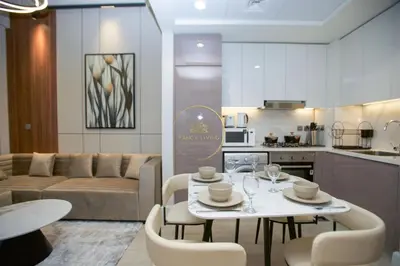 a kitchen and a living room with a table and chairs at Standard 1BHK located in Azizi Riviera 48 in Dubai
