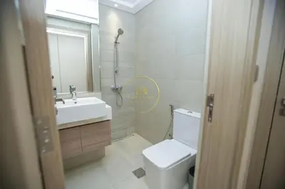 a bathroom with a toilet and a sink and a mirror at Standard 1BHK located in Azizi Riviera 48 in Dubai