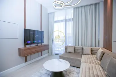 a living room with a couch and a tv at Standard 1BHK located in Azizi Riviera 48 in Dubai