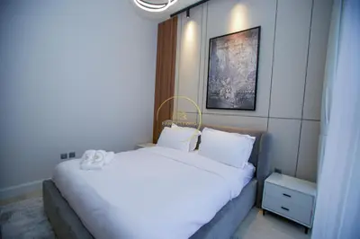 a bedroom with a large bed with white sheets at Standard 1BHK located in Azizi Riviera 48 in Dubai