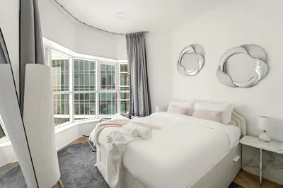 a bedroom with a white bed and mirrors on the wall at Bright Studio in Dubai Gate 2 in Dubai
