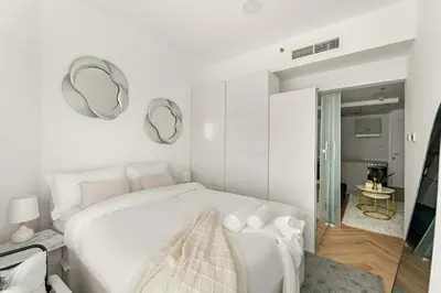 a bedroom with a white bed and mirrors on the wall at Bright Studio in Dubai Gate 2 in Dubai