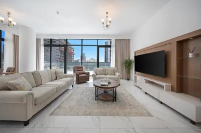a living room with a couch and a flat screen tv at Stylish 1BR with large Terrace JVC in Dubai