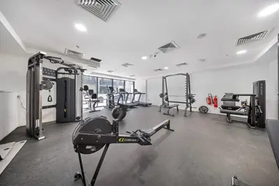 a gym with several treadmills and machines at Stylish 1BR with large Terrace JVC in Dubai