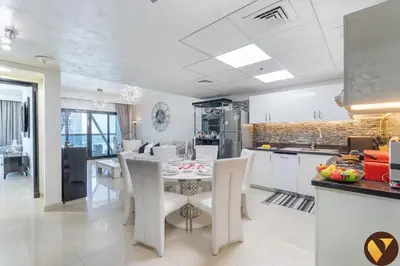 a kitchen and dining room with a table and chairs at Vogue DIFC Damac Park Tower near Museum of The Future, One Bedroom Apartment with Balcony, City Skyline and Museum of The Future View, Access to all Amenities in Dubai