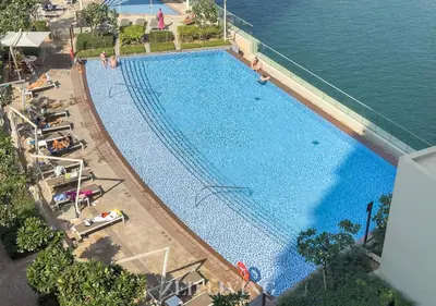an overhead view of a large swimming pool next to the water at Emaar 5242 - Stunning Sea View Stay in Prime Waterfront Location - Zed Living in Dubai