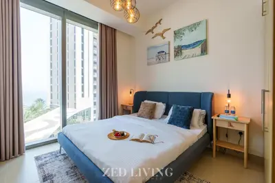 a bedroom with a bed with a large window at Emaar 5242 - Stunning Sea View Stay in Prime Waterfront Location - Zed Living in Dubai