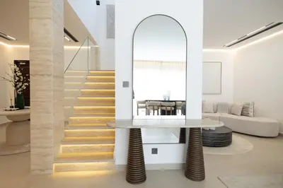 a living room with a table and a staircase at Designer Furnished Villa with Luxury Finishes in Springs 14 in Dubai