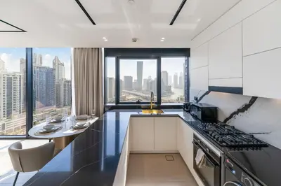 a kitchen with a view of a city skyline at FAM Living Trillionaire Residences Premium Studio with Private Jacuzzi and Canal View in Dubai