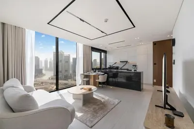 a living room with a white couch and a table at FAM Living Trillionaire Residences Premium Studio with Private Jacuzzi and Canal View in Dubai