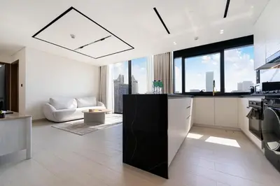 a kitchen and living room with a view of the city at FAM Living Trillionaire Residences Premium Studio with Private Jacuzzi and Canal View in Dubai