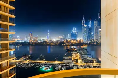 a view of a harbor with a city at night at Vogue Emaar Beach Front Marina Vista near JBR and Palm Jumeirah, Two Bedroom Apartment with Balcony and Private Beach, Access to all Amenities in Dubai