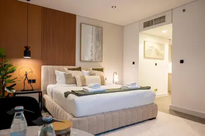 a bedroom with a large white bed and a couch at Damac Maison - Impression by UDH in Dubai