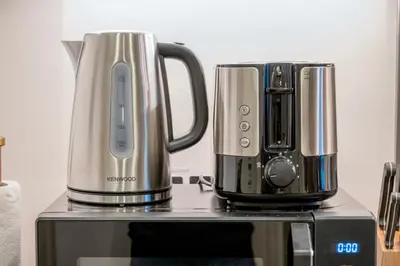 two stainless steel appliances sitting on top of a microwave at Damac Maison - Impression by UDH in Dubai