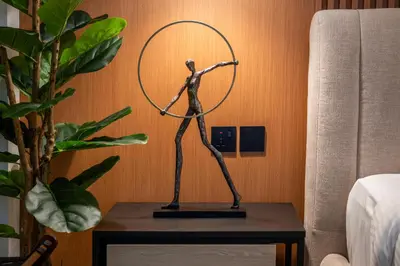 a metal statue of a man with a hoop on a table at Damac Maison - Impression by UDH in Dubai