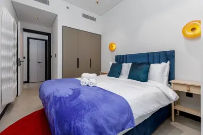 a bedroom with a blue and white bed with towels on it at Waves - Premium 1BR Apartment Overlooking Burj Khalifa in Dubai