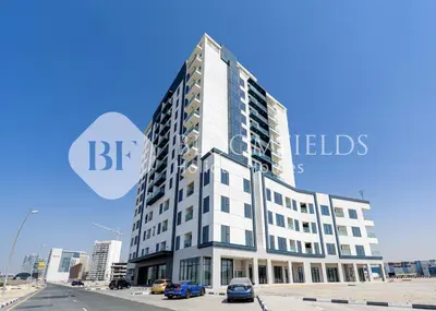 a tall white building with cars parked in front of it at Bloomfields Cozy Stu in Alexis Tower in Dubai