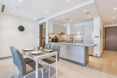 a kitchen and dining room with a table and chairs at STAY BY LATINEM Luxury 1BR Holiday Home WG2809 Near Burj Khalifa in Dubai
