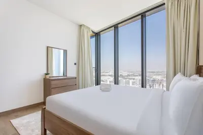 a bedroom with a large white bed and large windows at STAY BY LATINEM Luxury 1BR Holiday Home WG2809 Near Burj Khalifa in Dubai