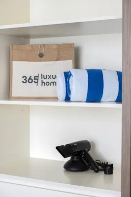 a shelf with blue and white towels on it at Designer 2-BR - Sea View - Grand Bleu by Elie Saab in Dubai