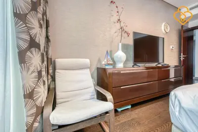 a bedroom with a chair and a dresser with a television at Keysplease Upgraded 1 BR Apt near Dubai Mall, Burj Views in Dubai